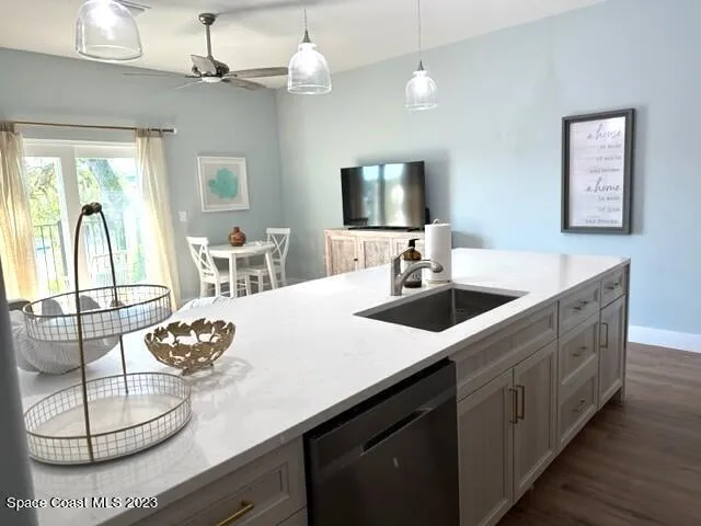 a living room with furniture a wooden floor and a view of kitchen