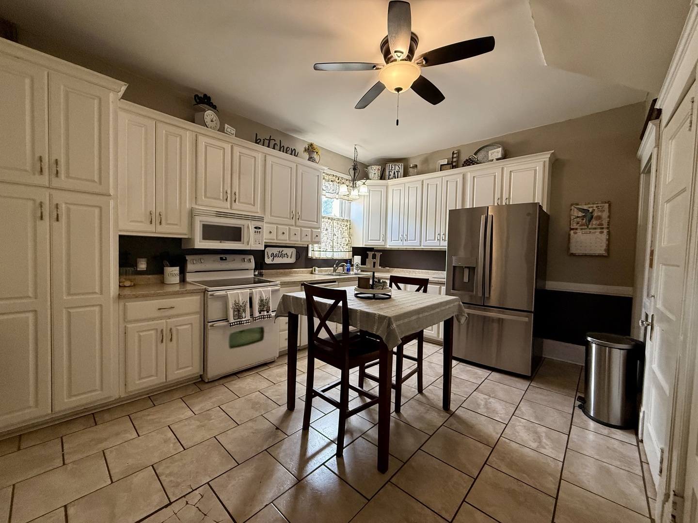 222 West Main Street Clinton, IL 61727 - Photo 9 of 25 a kitchen with stainless steel appliances kitchen island granite countertop a refrigerator a stove a sink a dining table and chairs with wooden floor