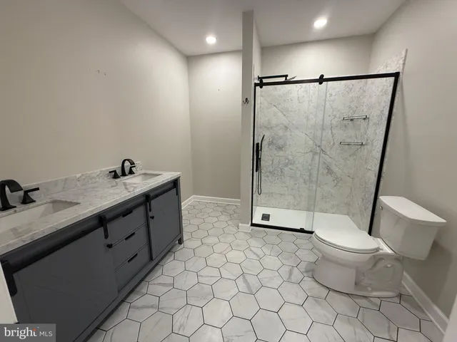 a bathroom with a double vanity sink toilet and shower