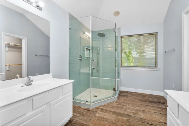 a bathroom with a shower sink and mirror