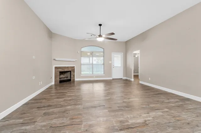 a view of an empty room with a fireplace and a window