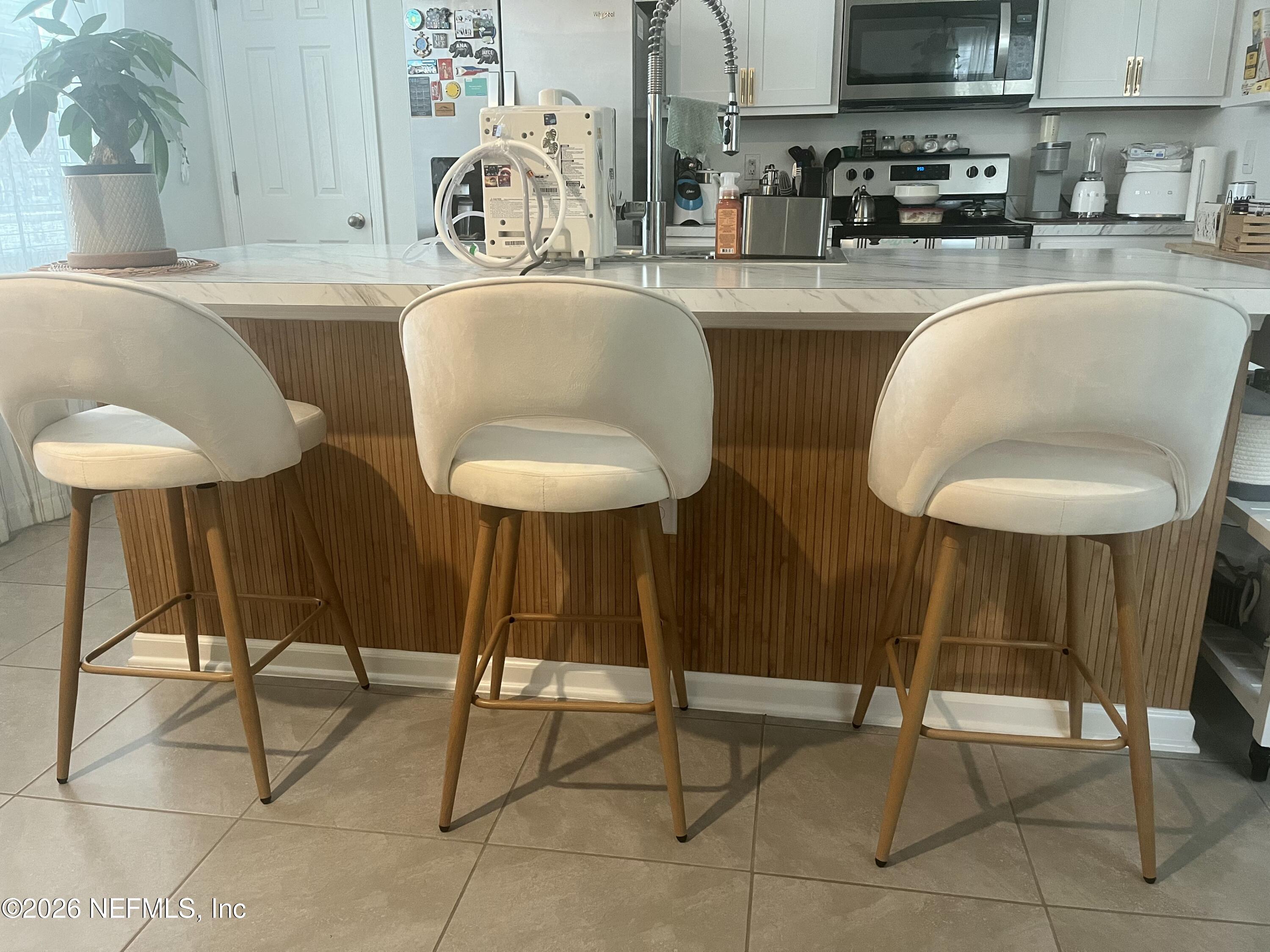 4935 Nebula Lane Jacksonville, FL 32256 - Photo 6 of 12 a kitchen with a table chairs sink and cabinets