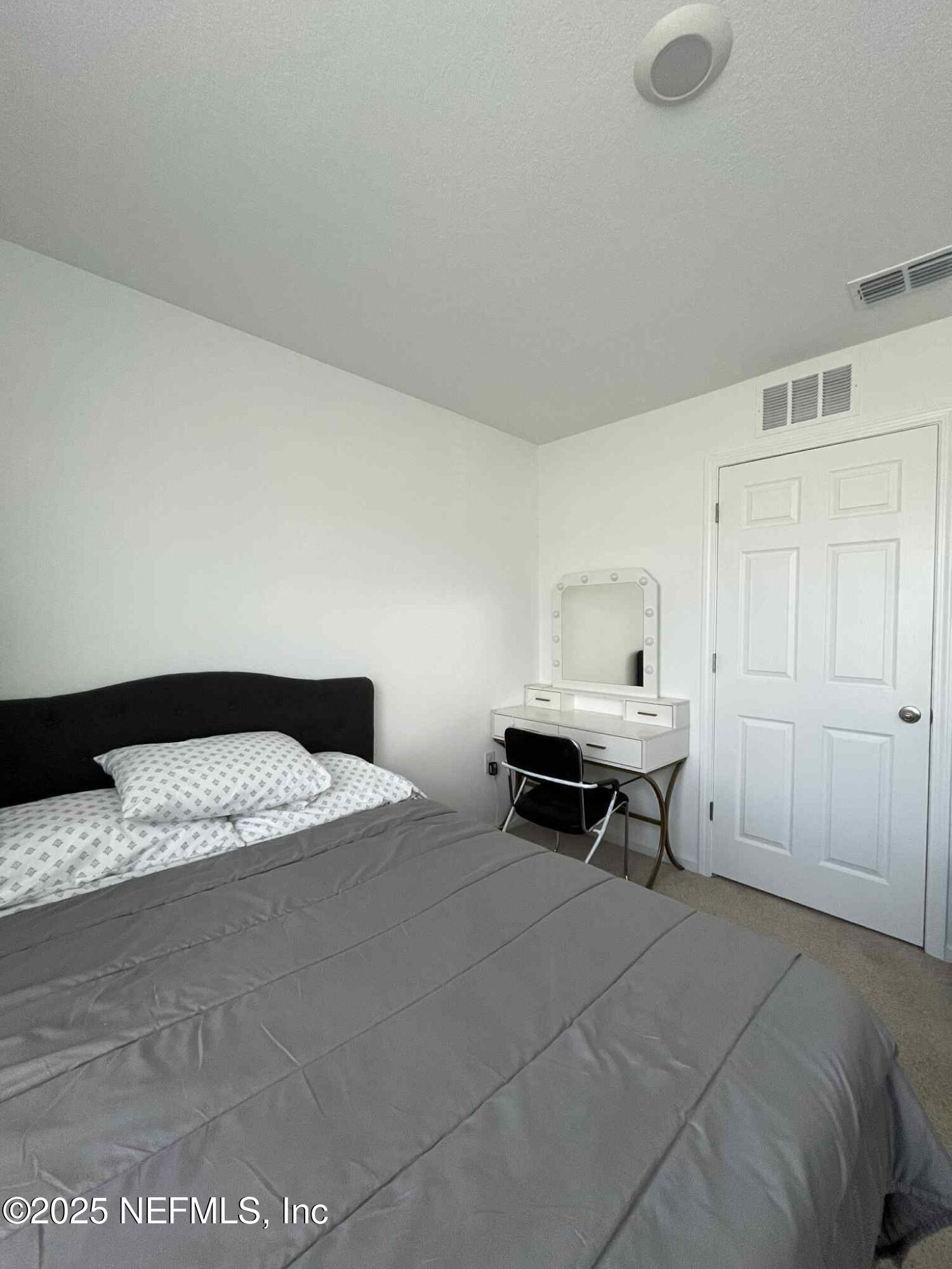 4935 Nebula Lane Jacksonville, FL 32256 - Photo 9 of 12 a bedroom with a bed and a table in it