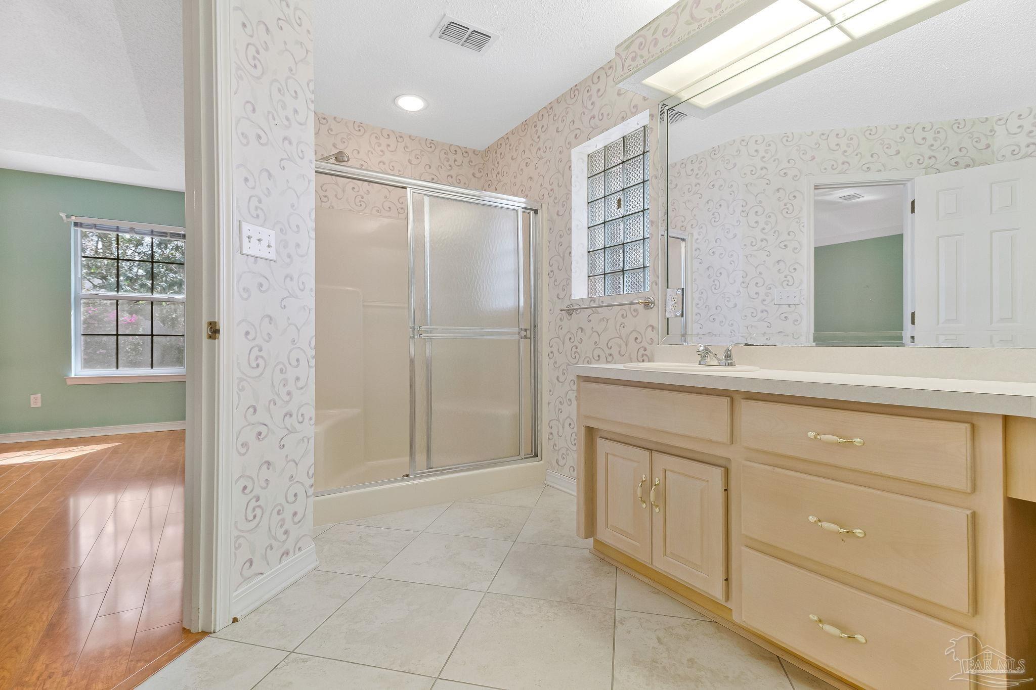 9320 Bell Ridge Drive Pensacola, FL 32526 - Photo 40 of 55 a bathroom with a granite countertop sink a mirror and a shower