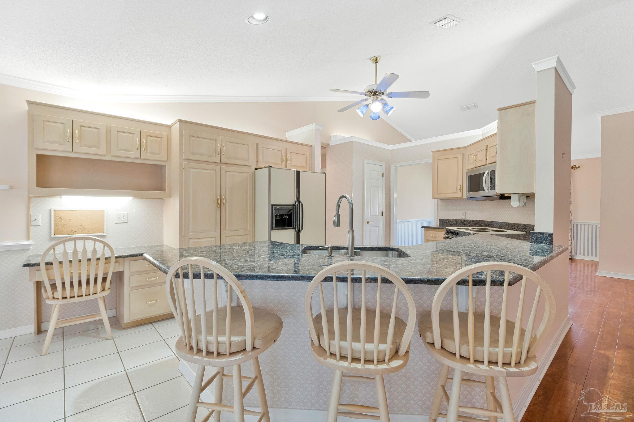 9320 Bell Ridge Drive Pensacola, FL 32526 - Photo 4 of 55 a kitchen with stainless steel appliances granite countertop a dining table and chairs