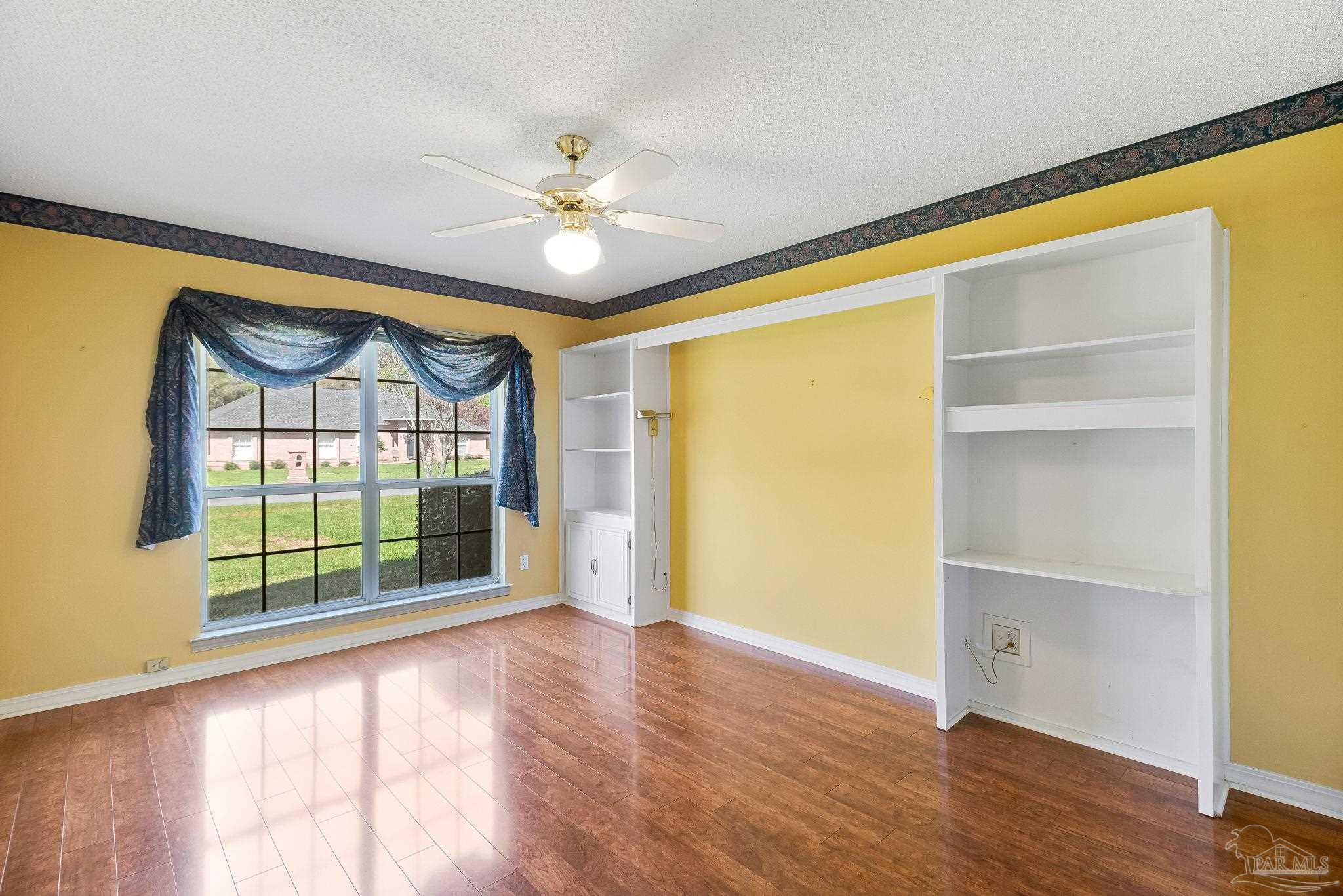 9320 Bell Ridge Drive Pensacola, FL 32526 - Photo 49 of 55 a view of an empty room with a window and wooden floor