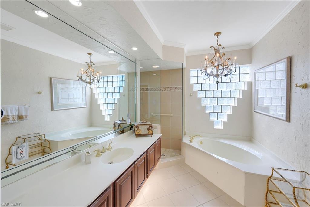 2147 Snook Drive Naples, FL 34102 - Photo 18 of 50 Full bath with a bath, suspended lighting, a textured wall, crown molding, and vanity