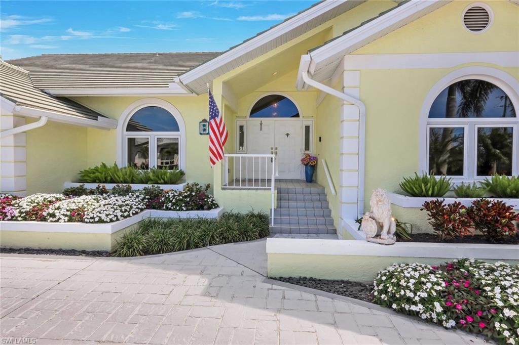 2147 Snook Drive Naples, FL 34102 - Photo 2 of 50 Entrance to property featuring stucco siding and covered porch