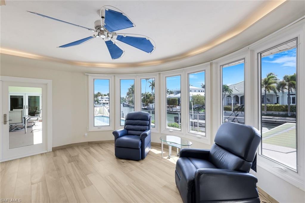 2147 Snook Drive Naples, FL 34102 - Photo 21 of 50 Living area with light wood finished floors, healthy amount of natural light, ceiling fan, and a tray ceiling