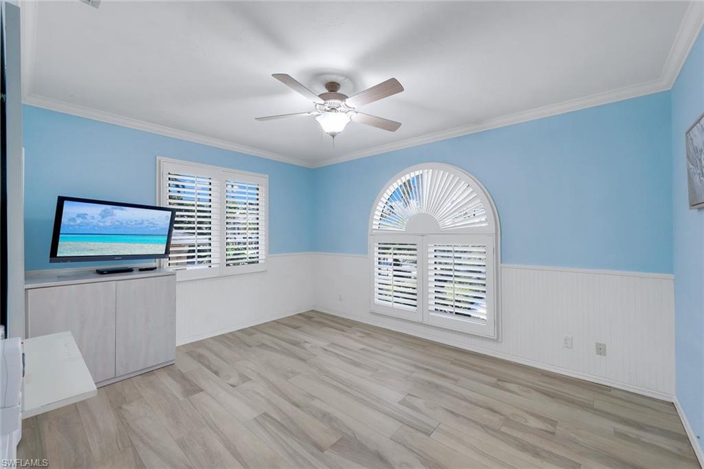 2147 Snook Drive Naples, FL 34102 - Photo 24 of 50 Unfurnished room with a wainscoted wall, ceiling fan, light wood finished floors, and crown molding