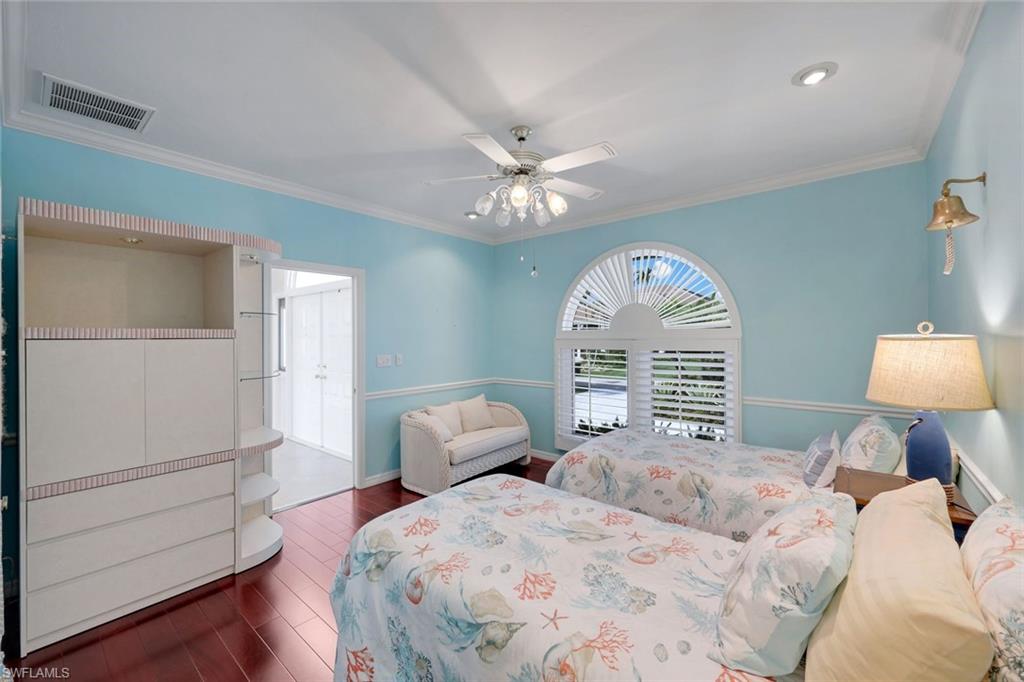 2147 Snook Drive Naples, FL 34102 - Photo 25 of 50 Bedroom with a ceiling fan, crown molding, and dark wood finished floors