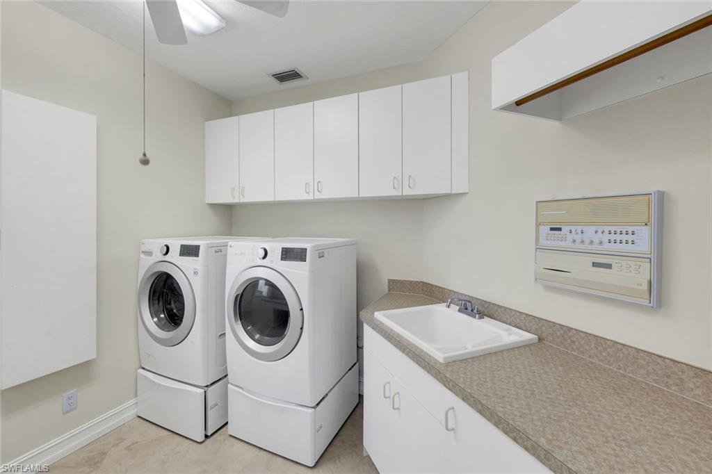 2147 Snook Drive Naples, FL 34102 - Photo 26 of 50 Laundry area featuring washing machine and dryer, cabinet space, and a ceiling fan
