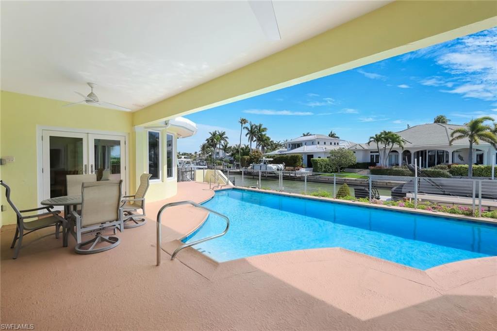 2147 Snook Drive Naples, FL 34102 - Photo 28 of 50 View of swimming pool with outdoor dining space, patio surround, and french doors