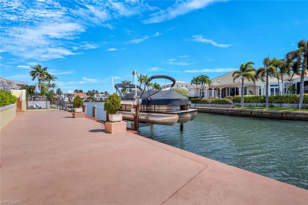 2147 Snook Drive Naples, FL 34102 - Photo 36 of 50 Dock featuring boat lift and a water view