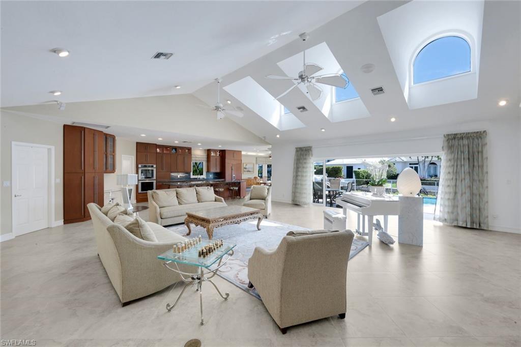 2147 Snook Drive Naples, FL 34102 - Photo 4 of 50 Living room with a ceiling fan, recessed lighting, a high ceiling, and a skylight