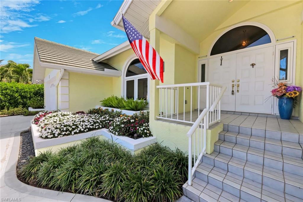 2147 Snook Drive Naples, FL 34102 - Photo 39 of 50 Entrance to property featuring stucco siding and covered porch