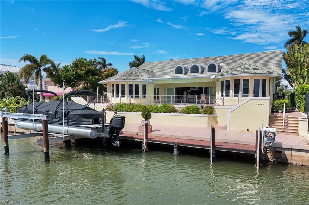 2147 Snook Drive Naples, FL 34102 - Photo 42 of 50 Back of property featuring a sunroom, a water view, boat lift, and a tile roof