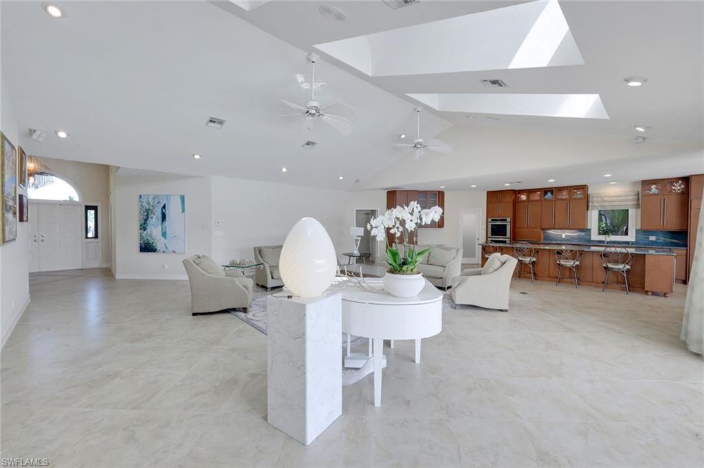 2147 Snook Drive Naples, FL 34102 - Photo 7 of 50 Living room with a skylight, recessed lighting, lofted ceiling, and light floors