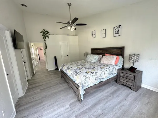 a bedroom with a bed and wooden floor
