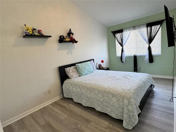 a bedroom with a bed and wooden floor