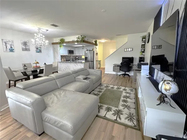 a living room with furniture a rug and wall painting