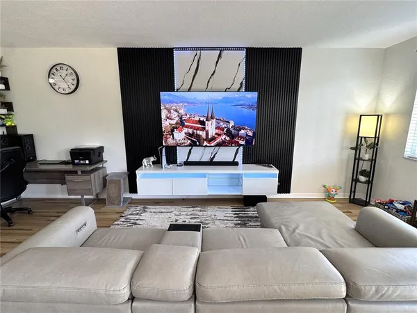 a living room with furniture a chandelier and a flat screen tv