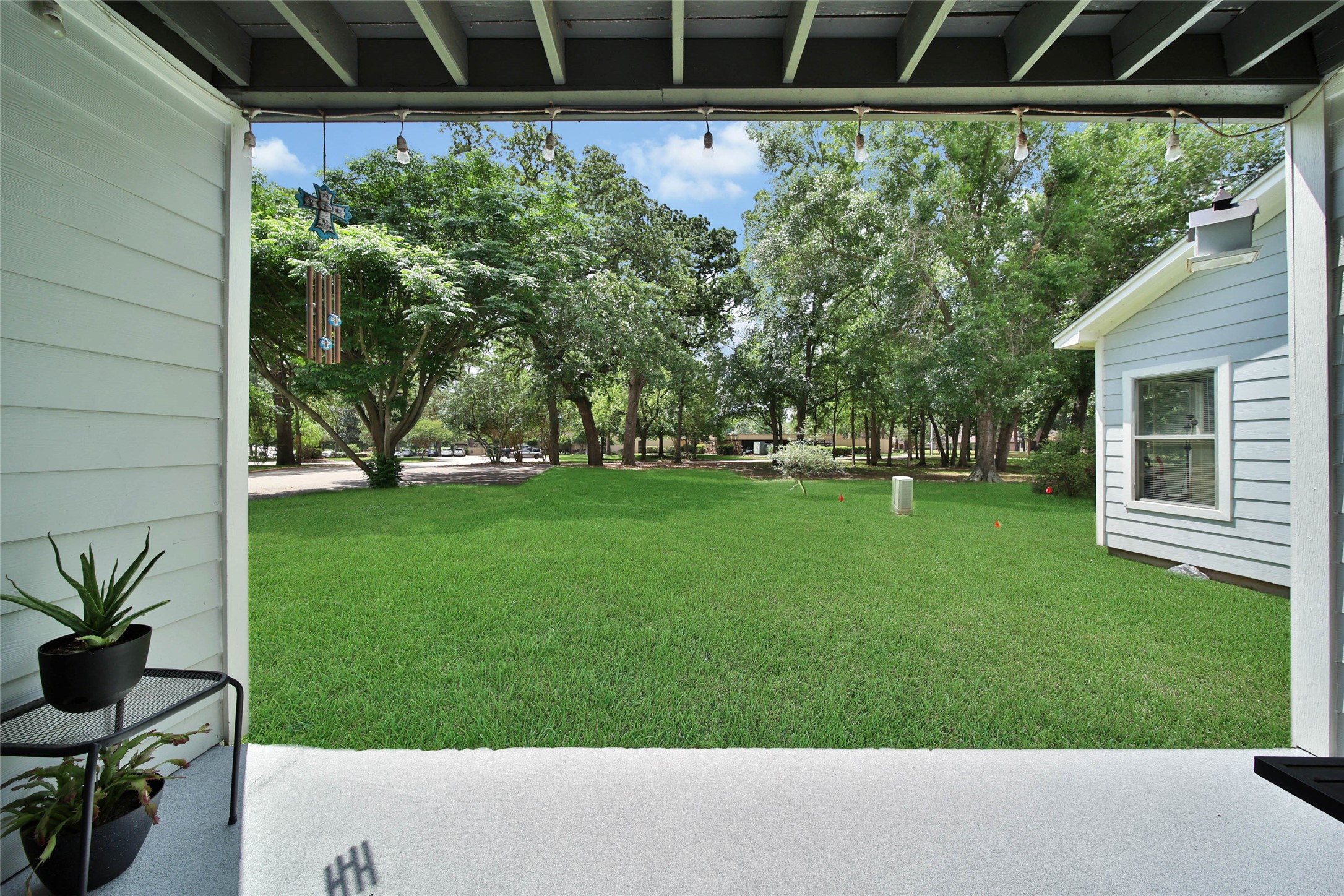 13151 Walden Road, Unit 119 Montgomery, TX 77356 - Photo 8 of 28 Let's showcase this charming backyard view from the covered patio. It features a well-maintained lawn bordered by mature trees, providing a serene and private outdoor space.