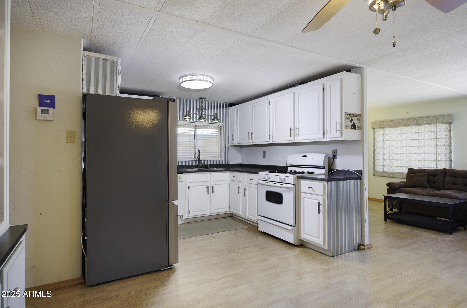 2100 North Trekell Road, Unit 20 Casa Grande, AZ 85122 - Photo 11 of 40 a kitchen with stainless steel appliances white cabinets and a refrigerator