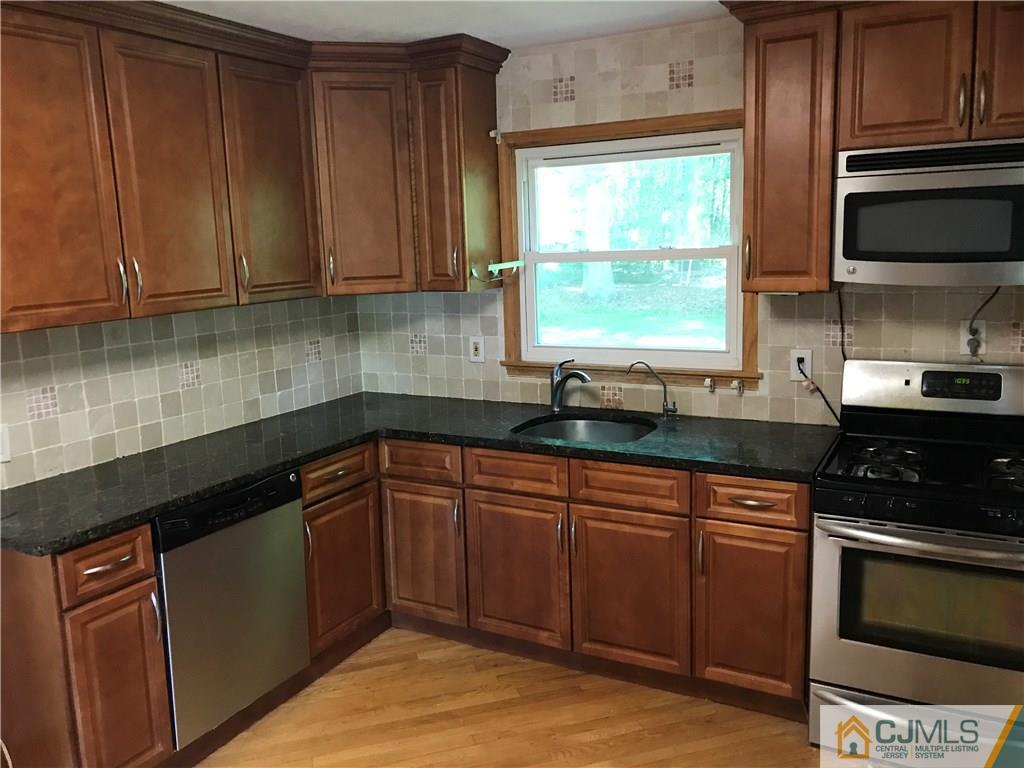 26 Francis Road East Brunswick, NJ 08816 - Photo 11 of 23 a kitchen with granite countertop wooden cabinets stainless steel appliances and a window