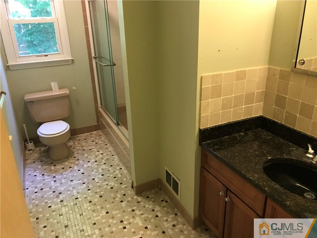 26 Francis Road East Brunswick, NJ 08816 - Photo 14 of 23 a bathroom with a granite countertop sink a toilet and a shower