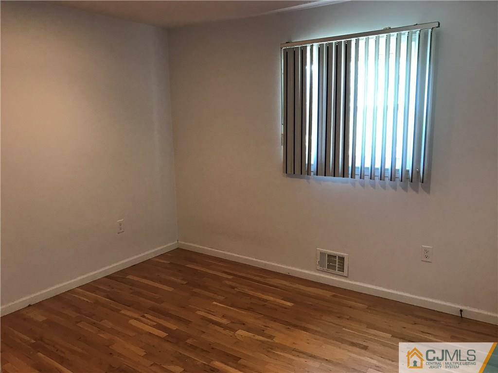 26 Francis Road East Brunswick, NJ 08816 - Photo 16 of 23 an empty room with wooden floor and windows