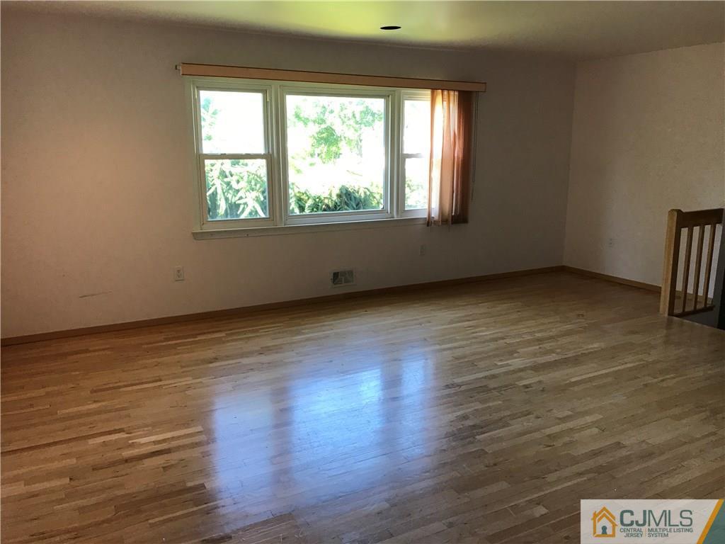 26 Francis Road East Brunswick, NJ 08816 - Photo 7 of 23 an empty room with wooden floor and windows