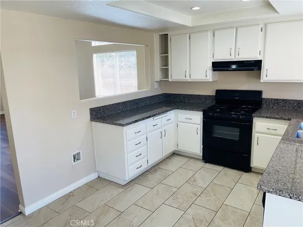a kitchen with granite countertop white cabinets and white appliances