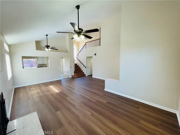 a view of a room with wooden floor white walls and a ceiling fan