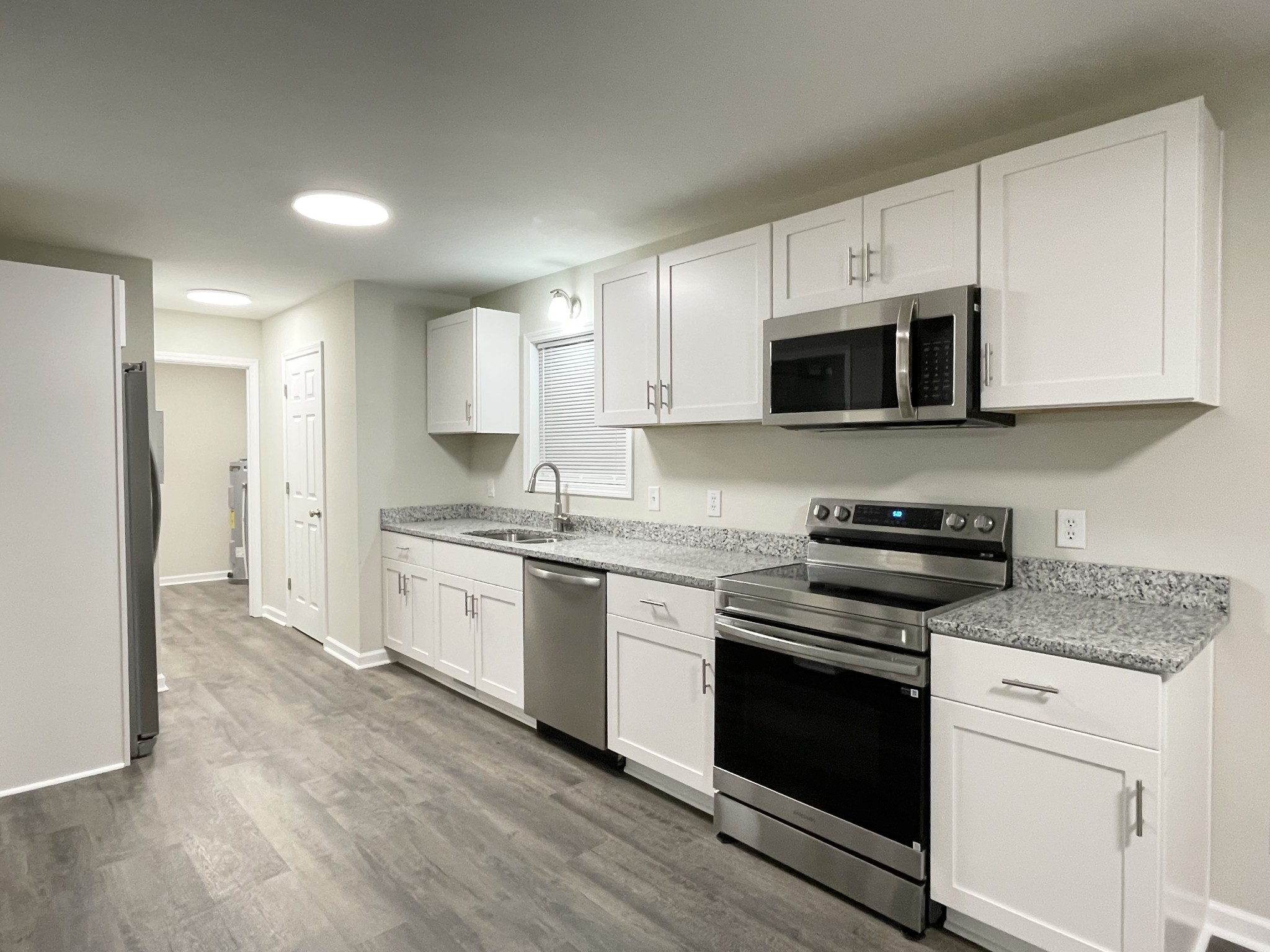 3060 Lylewood Road Woodlawn, TN 37191 - Photo 7 of 56 a kitchen with granite countertop a stove top oven a sink dishwasher and a refrigerator with wooden floor