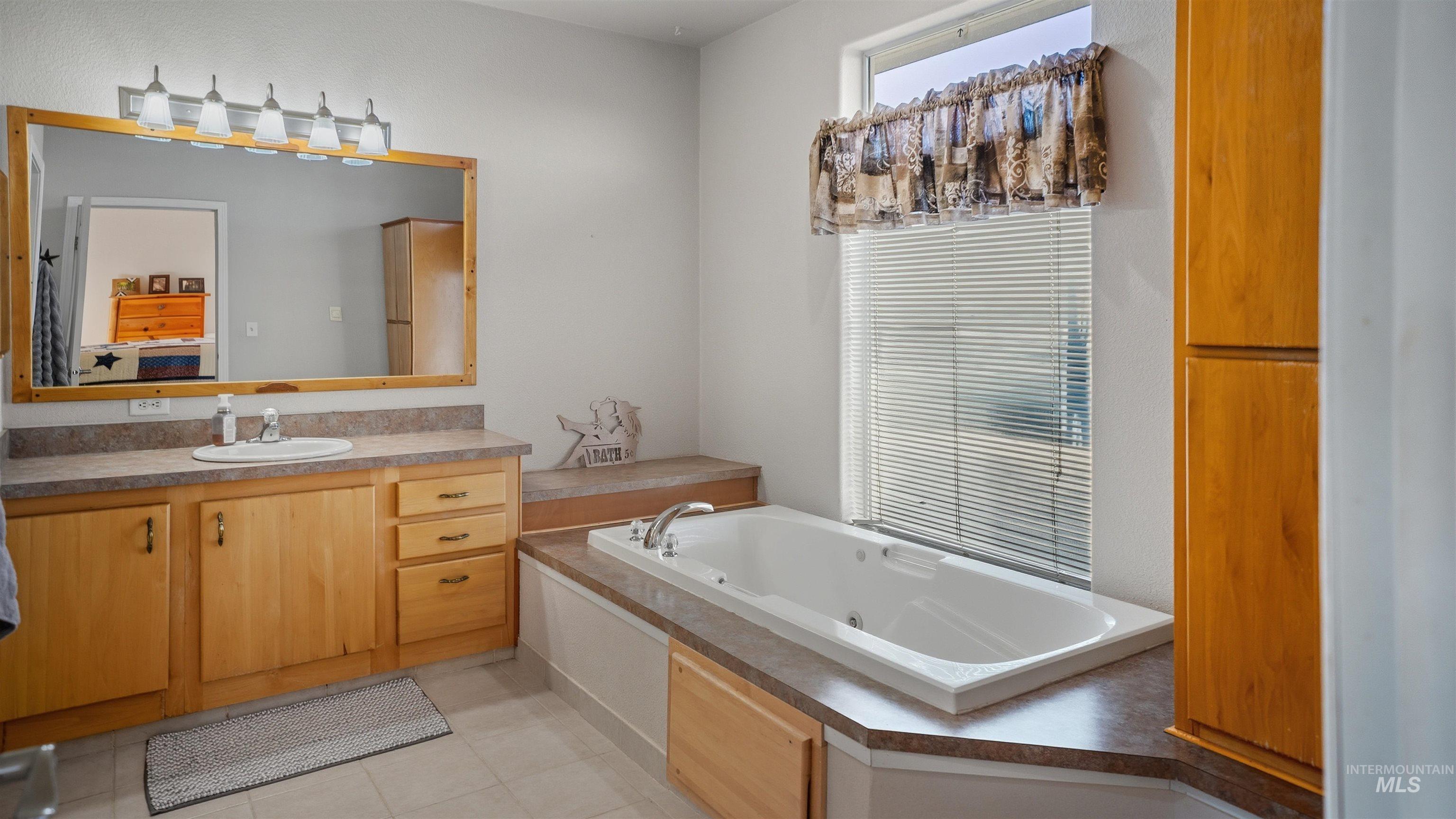 19397 Cloverland Road Asotin, WA 99402 - Photo 15 of 37 Bathroom with vanity, a tub with jets, and light tile patterned floors