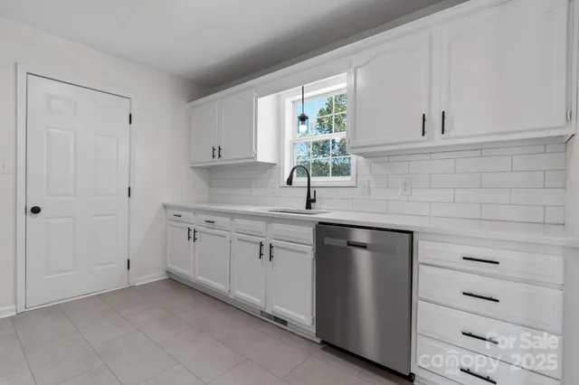 a kitchen with white cabinets and a sink