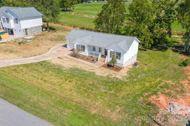 an aerial view of residential houses with outdoor space and trees