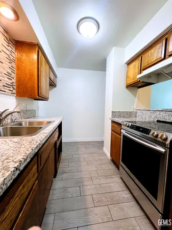 a kitchen with granite countertop a sink and a stove