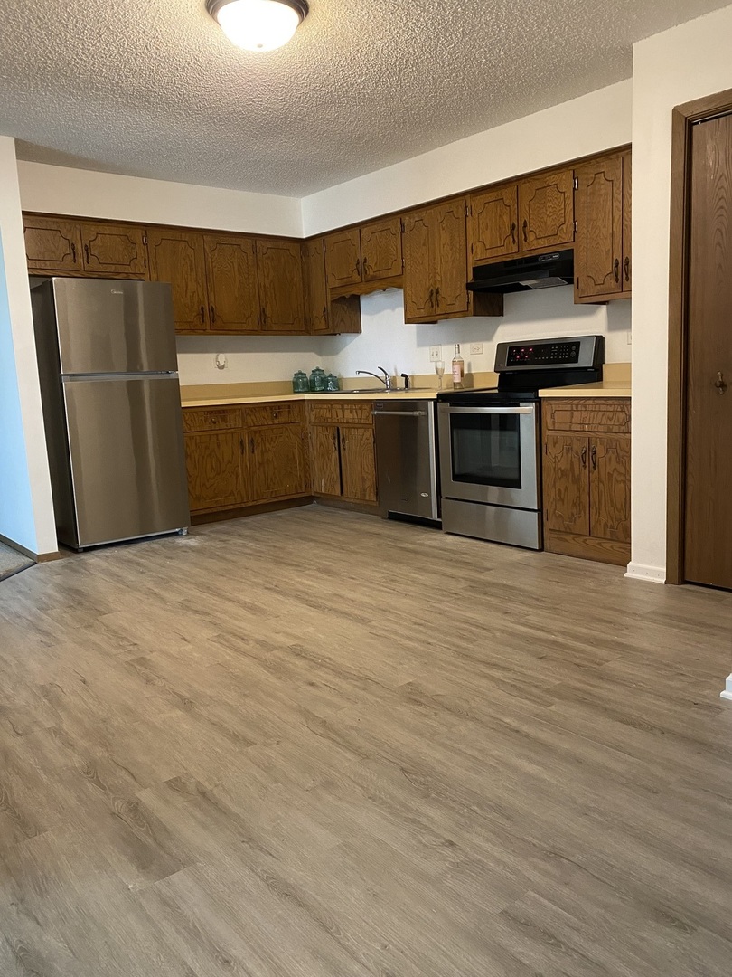 216 Madison Street, Unit 3D Joliet, IL 60435 - Photo 2 of 6 a kitchen with stainless steel appliances granite countertop a stove a sink and a refrigerator