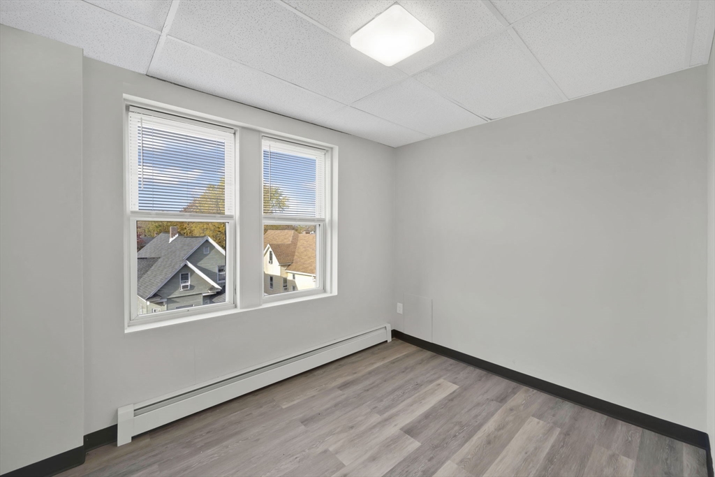 192-198 White Street Springfield, MA 01108 - Photo 12 of 29 an empty room with wooden floor and windows