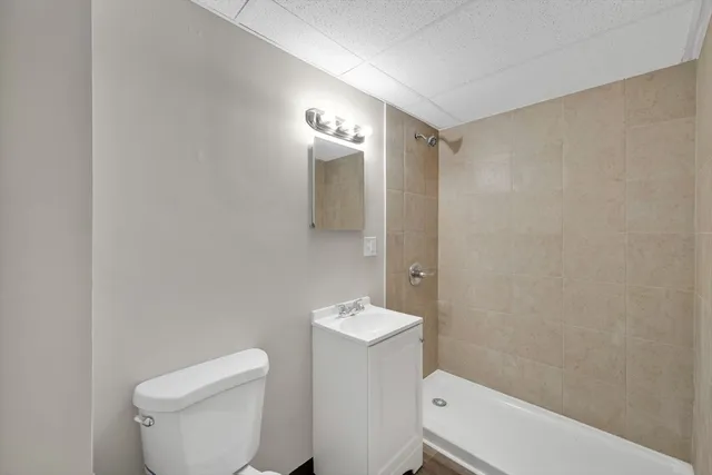 a white toilet sitting next to a bathroom sink and vanity