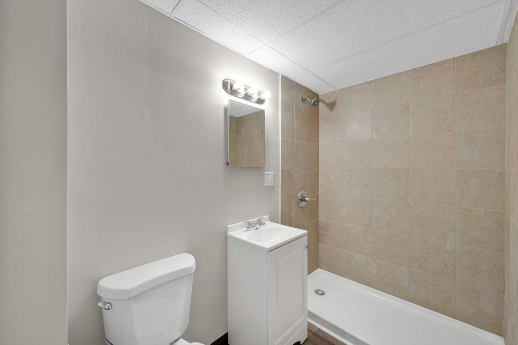192-198 White Street Springfield, MA 01108 - Photo 14 of 29 a white toilet sitting next to a bathroom sink and vanity
