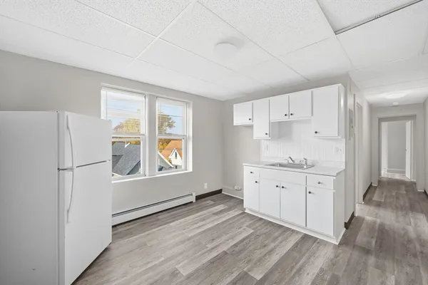 a kitchen with granite countertop white cabinets and white appliances