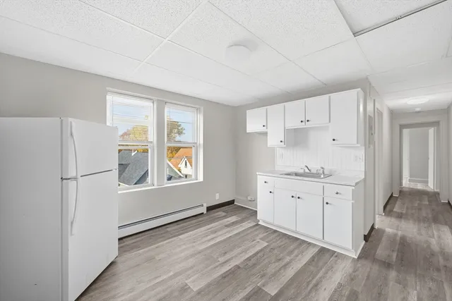 a kitchen with granite countertop white cabinets and white appliances