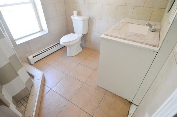 151 Mechanic Street Fitchburg, MA 01420 - Photo 16 of 42 a white toilet sitting next to a sink and vanity