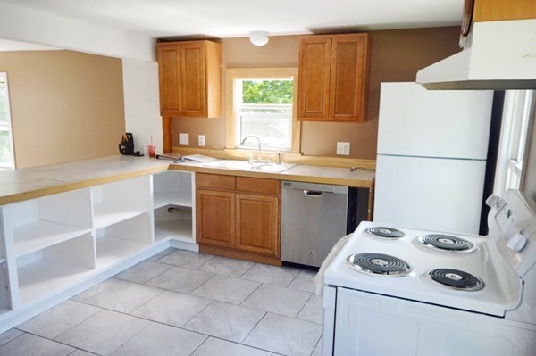 151 Mechanic Street Fitchburg, MA 01420 - Photo 10 of 42 a kitchen with a sink a stove a refrigerator and a window