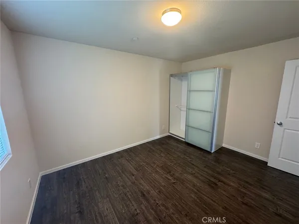 an empty room with wooden floor and sink