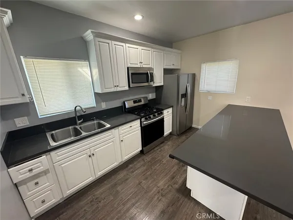 a kitchen with stainless steel appliances granite countertop a sink dishwasher a stove and a microwave oven on granite countertops