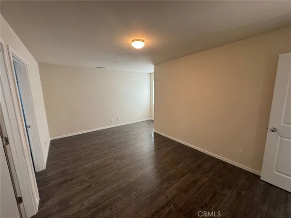 an empty room with wooden floor and door